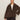 A woman wears the Sanctuary Clothing colette fur jacket choco chip extended sizing, featuring dark brown faux fur with large lapels and two buttons, over a white top and dark pants, standing against a plain light background.