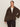 A woman wears the Sanctuary Clothing colette fur jacket choco chip extended sizing, featuring dark brown faux fur with large lapels and two buttons, over a white top and dark pants, standing against a plain light background.