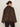 A woman with dark hair in a bun models the Sanctuary Clothing colette fur jacket choco chip (extended sizing) with black pants, facing away from the camera against a plain light background.