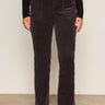 A person wears Sanctuary Clothing's Corduroy Hayden Bootcut Pant in Semi Sweet (extended sizing) with front patch pockets, paired with a black long-sleeve top and black ankle boots, against a light background.