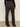 A person is shown from the back wearing Sanctuary Clothing's corduroy Hayden bootcut pant in semi sweet, featuring high-waisted style and patch back pockets, paired with black heeled boots and a black top against a plain background.