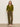 A woman stands against a plain light wall, hands in her pockets, wearing Sanctuary Clothingžs must have cardi martini olive, paired with olive cargo pants and light woven slip-on shoes, her expression neutral.