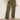 A person wears Sanctuary Clothing's boyfriend utility high rise pant in kalamata, styled with a light top and leopard print flats, standing against a plain background.
