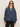 A woman in Sanctuary Clothingžs personal best blouse moonshadow�a loose, long-sleeve denim top with a gathered yoke and buttoned collar�pairs it with black pants, standing against a plain light background.