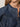 Close-up of a woman in the Sanctuary Clothing personal best blouse moonshadow. The blue denim, collarless shirt features gathered yoke detailing and front buttons. Her lips and chin are partially visible.