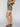Wearing Sanctuary Clothing's Spring Breaker Short in Mezzo Sage and a matching top, with brown strappy sandals and a gold bracelet, a person stands against a plain light background.