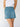 A person in a white sleeveless top and Sanctuary Clothing's all buttoned up skirt dream team, featuring front buttons and large pockets, stands against a plain light background.