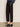 Model wears the Sanctuary Clothing ponte barrel trouser in black, paired with heeled mules. Image is cropped from the waist down, showing hands in pockets while standing on a plain floor.