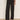 A person wearing Sanctuary Clothing's Charter Gab Barrel Pant in black, styled with a long-sleeve animal print blouse and black heeled mules, stands against a plain background.