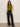 A woman wearing Sanctuary Clothingžs fuzzy shell martini olive sleeveless turtleneck top and black wide-leg trousers poses with her hands in her pockets against a plain light background.