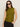 A woman with straight brown hair and black sunglasses wears the Sanctuary Clothing fuzzy shell martini olive sleeveless turtleneck sweater and black pants against a plain light background.