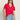 A woman with long brown hair wears the Sanctuary Clothing notch neck tee radiant, light blue jeans, and black oval sunglasses, standing with one hand in her pocket against a neutral background.