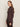 A woman with long brown hair models the Sanctuary Clothing ls mock essential top in semi sweet, standing sideways against an off-white background and looking towards the camera with a neutral expression.