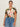 A woman with dark hair tied back wears Sanctuary Clothing’s the perfect tee reef vibes extended sizing, tucked into high-waisted blue jeans. She stands against a light background, looking confidently at the camera.