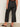 A person is indoors with their back to the camera, showing only their lower half, wearing Sanctuary Clothing's the marine jeans after hours extended sizing.