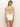 A woman with long blonde hair wears the Sanctuary Clothing "refresh rib v wire mio white" swimsuit, featuring thin straps and a crisscross lace-up back detail. She stands against a minimalist backdrop.