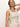 A woman models the Sanctuary Clothing Outsmart Square Neck Vest in flax, showcasing her long hair and minimal jewelry with one hand behind her head against a simple light background.