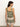 A woman with long dark hair stands against a plain background, wearing the Sanctuary Clothing button back cami in mezzo sage with matching shorts. The ensemble features an intricate floral and geometric pattern in white, pink, and gold as she faces slightly away from the camera.