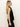 Woman with long, straight blonde hair wears Sanctuary Clothing's "the long weekend tank black" with black pants, standing in profile against a plain light background.