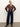 A person stands against a plain background, wearing the personal best blouse boheme by Sanctuary Clothing, paired with dark wide-leg jeans, a brown belt, and black heeled ankle boots. Their light hair is pulled back as they pose with relaxed confidence.