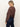 A woman with blonde hair in a low ponytail wears the Sanctuary Clothing personal best blouse boheme and dark denim jeans, standing sideways and looking down over her shoulder against a plain background.
