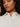 A woman with curly hair wears gold hoop earrings and the Sanctuary Clothing new era tuxedo shirt white extended sizing, posing against a plain background.