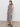 A person is wearing Sanctuary Clothing's "Contrast Trim Maxi Dress" in black macramé stripe, featuring a sleeveless design that reaches below the knees. They pair it with black sandals while standing on a plain floor against a white background.
