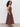 A woman with curly hair stands in profile, wearing the Sanctuary Clothing "take me away midi dress mesa" against a plain white background.