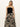 A person with long blonde hair models Sanctuary Clothing's "meet me at sea" midi dress in black mirage, set against a plain white background.