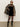 A woman wears the Sanctuary Clothing party shift dress in black, styled with sunglasses, sheer tights, knee-high boots, and a leopard print coat draped over her shoulders, standing against a plain background.