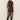 A woman poses against a plain light background in the Sanctuary Clothing night out mock sweater dress semi sweet, a fitted black dress with three-quarter sleeves and side slit, paired with knee-high black boots.