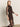 A woman with straight blonde hair models the Sanctuary Clothing night out mock sweater dress semi sweet— a fitted, sheer black design with three-quarter sleeves and a high neck, posed against a plain light wall.