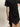 A person wears the Sanctuary Clothing "satin mix tshirt dress black" featuring short sleeves, a twisted knot waist, lace-trimmed hem, and asymmetrical cut, with their right hand on their hip.