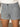 A person wearing Sanctuary Clothing's voyage short yacht stripe—blue and white vertical striped shorts with front button and two pockets—paired with a white top.