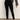 A person models the Sanctuary Clothing runway legging black, paired with a loose dark gray long-sleeve top and black ankle-strap shoes, posed with one hand on their hip against a plain light background, head out of frame.