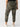 A person wearing the Rebel Pant Hiker Camo from Sanctuary Clothing's Inclusive Collection and white sneakers with a visible "V" logo on the back stands with their back facing the camera. The pants have pockets on the sides and back, and the sneakers feature light beige accents on the heel and sole.