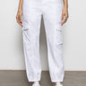 A person wearing Sanctuary Clothing's rebel pant in brilliant white, paired with white sneakers and a black top. Only the lower half of the body is visible, standing against a plain light-colored wall.