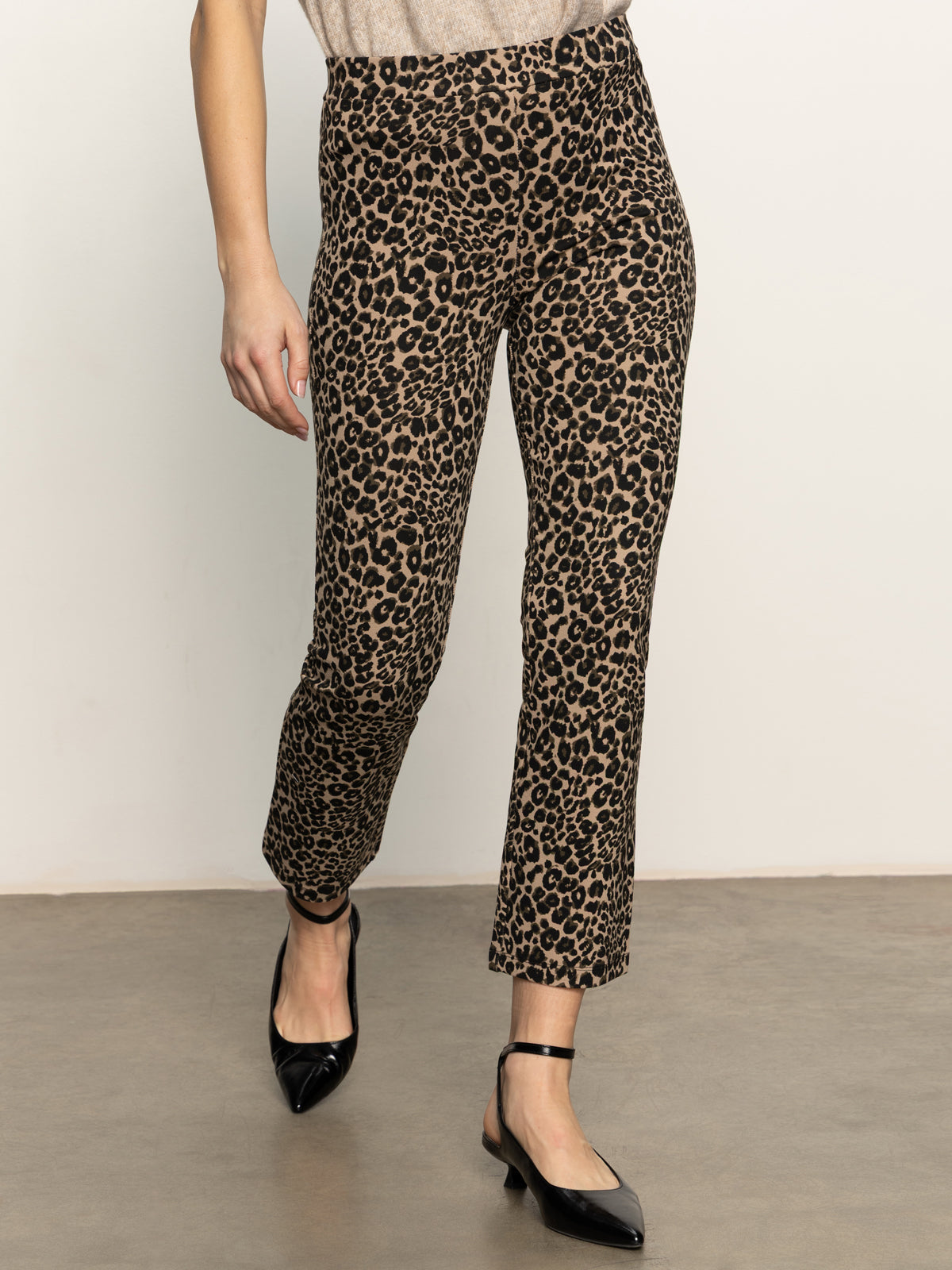 The lower half of a person is shown wearing Sanctuary Clothing's carnaby kick crop leggings in french kitty, standing on a gray floor against a plain off-white background.