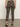 A person stands facing away from the camera, wearing Sanctuary Clothing’s carnaby kick crop leggings in French Kitty print with black strappy low-heeled shoes. The background is neutral and plain.