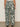 A person stands facing away, wearing the soft trouser green oasis from Sanctuary Clothing—high-waisted, wide-leg, loose-fitting pants in extended sizing. The background is plain and neutral.