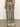 A person is seen from behind wearing "the soft trouser mezzo sage" by Sanctuary Clothing. The pants feature a green and beige pattern with ornate symmetrical designs, a relaxed fit, and decorative hems against a neutral backdrop.