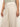 A person wearing the linen marine wide leg birch pants by Sanctuary Clothing with large front pockets and a striped top. A gold ring shines on their visible right hand.