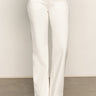A person wears Sanctuary Clothing's corduroy marine pant in chalk, paired with light beige suede shoes, standing on a gray floor against a neutral background.