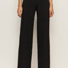 A person is shown from the waist down wearing Sanctuary Clothing's black runway ponte trouser with black shoes, standing against a plain light background.