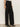 A person wearing Sanctuary Clothing’s runway ponte trouser in black with black heeled boots, standing against a plain light wall. Only the lower half of their body is visible.