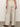 The rear view of a person in Sanctuary Clothing's hopper straight leg flax with a matching top, stands on concrete. They wear brown sandals and sport a bracelet on their left wrist and rings on their fingers.