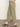 A person wears Sanctuary Clothing's district column ankle jean in bamboo, paired with black heeled sandals, standing on a polished floor against a plain light-colored wall, with only their lower body visible.