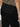 A person wearing the Sanctuary Clothing sahara tapered pant in black stands with their back to the camera, showing back flap pockets and a Sanctuary label above the right pocket.