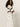 A person with long curly hair stands sideways in a white short-sleeve crochet top with black stripes and Sanctuary Clothing™s area standard rise pant in bleached white, featuring patch pockets, against a plain light background.