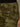 Close-up of a person wearing Sanctuary Clothing's rio pant rambler camo, featuring green camouflage pattern, front pocket, belt loop, and a visible dark waistband. A hand rests at their side.